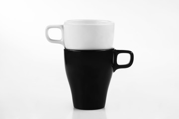 White mug and black mug on a white background