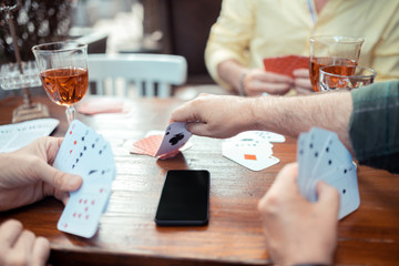 Man reaching his hand while taking card from the table
