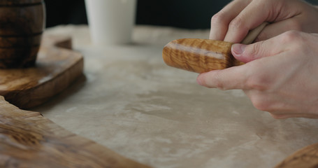 woodworker applying oil finish to olive wood scoop