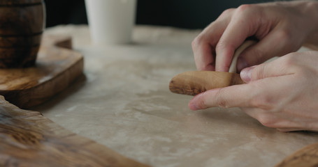 woodworker applying oil finish to olive wood scoop