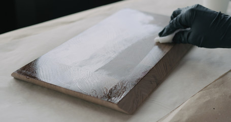 woodworker applying oil finish to walnut end grain wood board