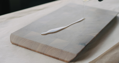 woodworker applying oil finish to walnut end grain wood board