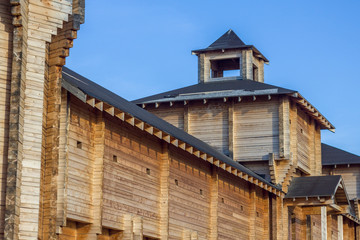 high defensive wall of an ancient wooden fortress with a bell tower