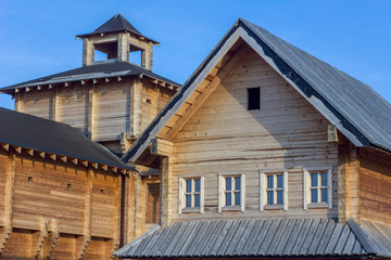 houses of an old wooden fortress with high defensive walls and a bell tower