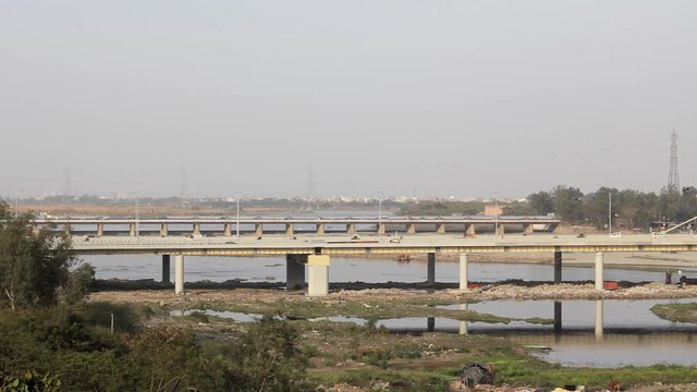 automobile city traffic on the Signature cable-stayed bridge across the Yamuna River in Delhi against the background of the city