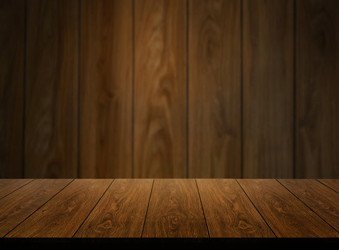 Wood table in front of wood wall blur background with empty copy space on the table for product display mockup. Retro design montage presentation.