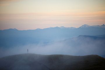 Fototapeta na wymiar Photo of evening foggy mountain landscape with red sky