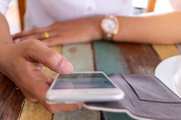 women playing electronic games on the phone while waiting food orders in restaurant