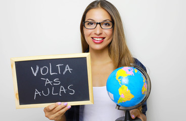 Brazilian young female teacher holding globe and blackboard with portuguese written 
