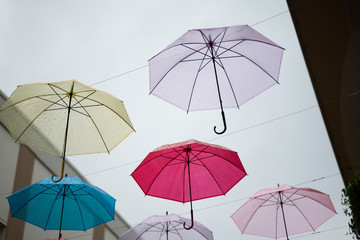 Multi-colored umbrellas in the sky on heavy rainy days