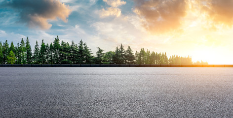 Fototapeta premium Country asphalt road and green woods nature landscape at sunset