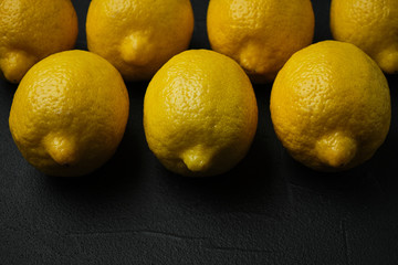 fresh whole lemons on dark background with space for text. top view