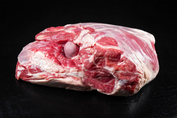 Traditional raw leg of lamb as top view on a slate slab with copy space