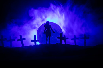Naklejka premium Girl walking alone in the cemetery at night.