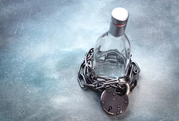  Alcoholism, alcohol addiction concept with alcohol drink bottle and chain with lock. Stop drink background. Copy space. © Dmytro