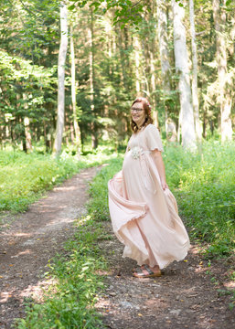 Frau freut sich auf ihr Baby, Schwangerschaft, tanzen im Wald