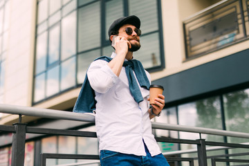 Young man walking on the street and using his smartphone