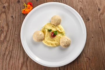 Mashed potatoes with steam meatballs on a white plate