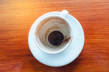 Top view of empty hot coffee cup after drink on wood table background.
