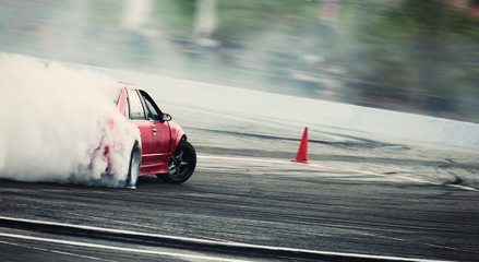 Blurred of diffusion race drift car with lots of smoke from burning tires on speed track .