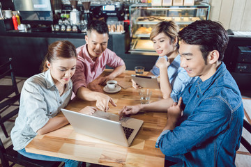Friends looking at laptop in the coffee shop