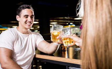 Cheerful friends in the pub. Drinking beer, talking, having fun.