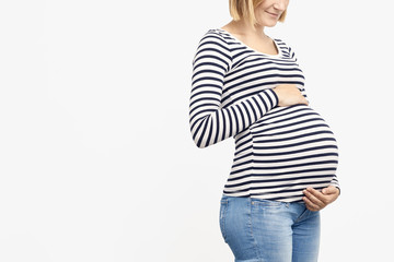 Young pregnant woman looking and smiling at stomach