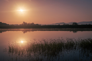 Sun rising over the calm peacful and tranquil lake in Bulgaria