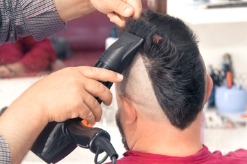A man with a mohawk in a barbershop. Laying, drying.
