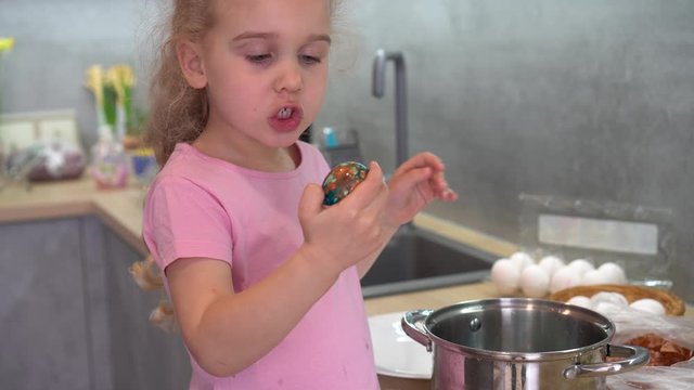 Playful little girl look at painted eggs and simper in front of camera. gimbal