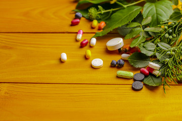 composition with fresh herbs and pills on wooden background
