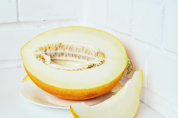 Ripe yellow melon on white background. Ripe yellow melon on a white table.