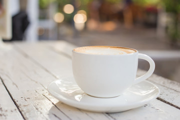 A cup of coffee on table with green nature background,Latte art of coffee at cafe shop