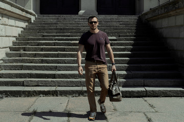 a man walks with a bag along the street