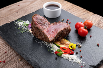 Filet Mignon steak with sauce on black slate