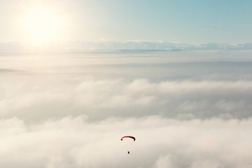 paraglider in the sky against mountains