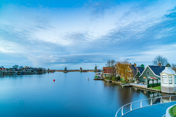 Obraz premium Twilight view of typical dutch houses with windmills and the River Zaan