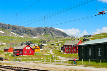Tourist biking and colorful houses in Finse, Norway, on July 28 2019
