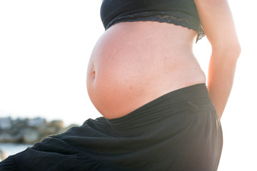 Pregnant woman, belly seen against the sun