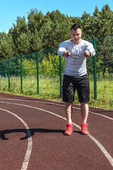 athletic man at the stadium with a skipping rope. Healthy lifestyle. Sport activities on the street