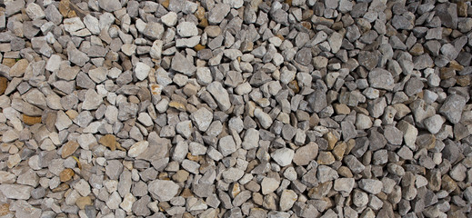 Construction breakstone background. Gravel road texture. The grey building rubble.