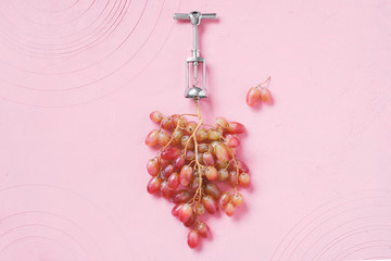Natural wine production concept. Fresh ripe bunch of grapes with metal corkscrew