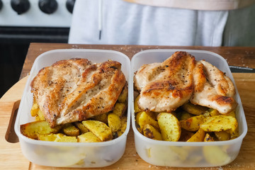 Fried potatoes with chicken breast in plastic containers