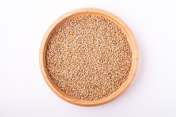 Wheat seeds grains in wooden bowl, top view, flat lay, isolated on white background