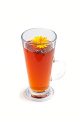 Glass of herbal tea with calendula and hyssop isolated on white background . Side view, close up.