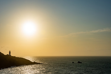Nostalgic picture of lighthouse lonely standing at the steep coast of south Devon during sunrise in a beautiful warm color tones