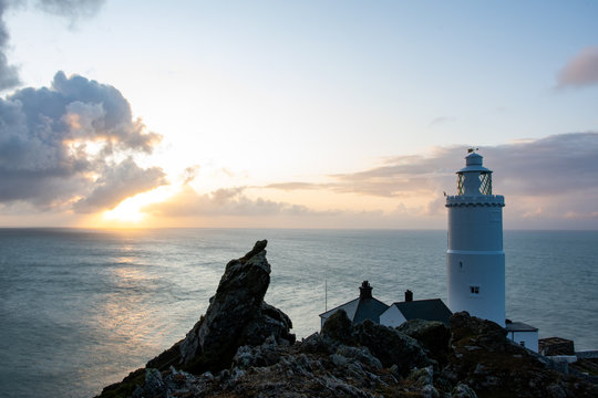 Lighthouse during sunrise in a view from top of a rock near the tower
