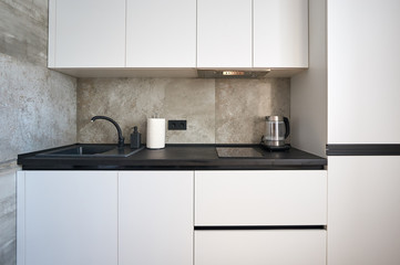 white minimalist kitchen with black countertop and sink