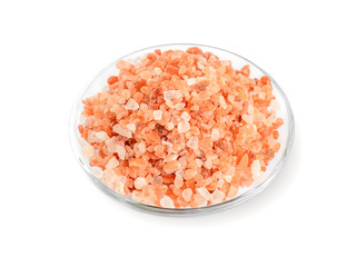 Fototapeta na wymiar Large crystals of pink himalayan salt in a glass saucer isolated on white background. Himalayan salt is used in cooking, medicine and cosmetology.