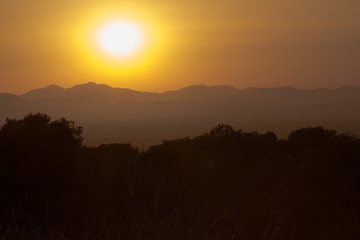 a sunset behind the mountains during a warm Summer evening in Augsut seen over Alicante City 